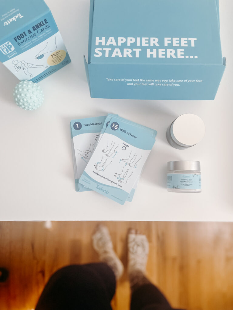 Table with foot and ankle exercise cards and happier feet packaging with a girl wearing Tucketts toeless grip socks 