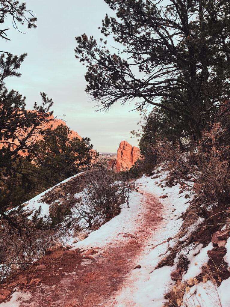 a hiking path at garden of the gods park covered in snow